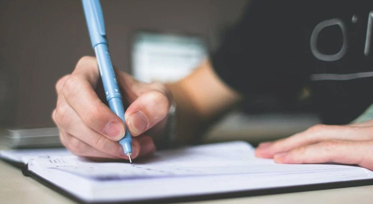 Picture of a person writing on a page